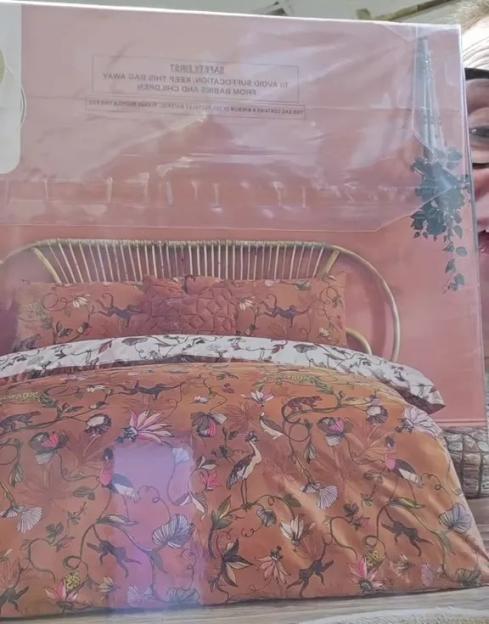 Packaged duvet cover set with a floral and animal pattern.