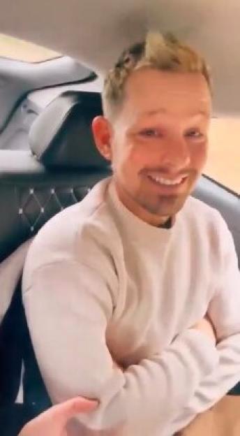 Actor Adam Rickitt smiling in a car.
