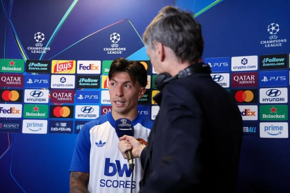 Manchester United player being interviewed in front of a branded backdrop during the UEFA Champions League.