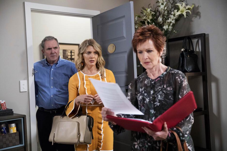 Susan, caught going through documents in a hotel room, is confronted by two others.