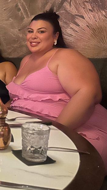 Lizette Watson smiling while sitting at a table with a drink.