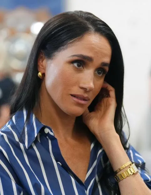 Meghan, Duchess of Sussex, wearing a blue and white striped shirt, during a visit to Bondi Beach.