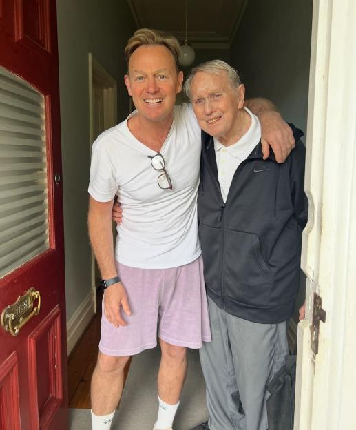 Jason Donovan embracing his 90-year-old father, Terence Donovan.
