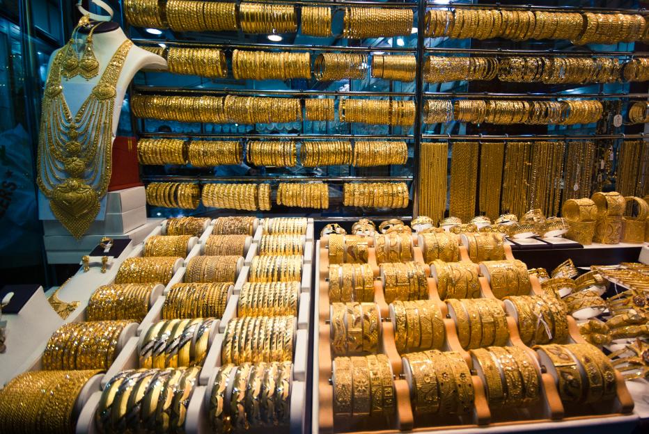A large display of gold jewelry including necklaces, earrings, and rows of bangles in various designs.