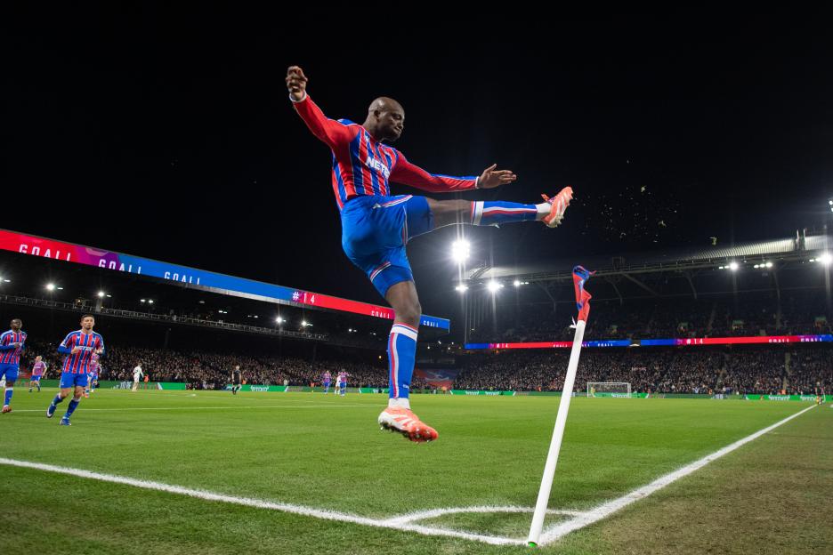 Jean-Philippe Mateta of Crystal Palace celebrates scoring a goal, kicking up confetti from the corner flag.