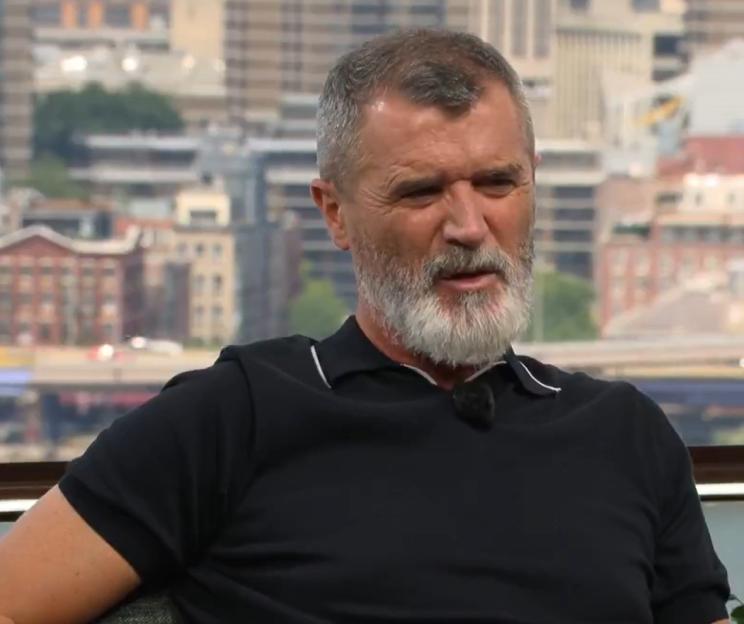 Roy Keane in a black polo shirt.