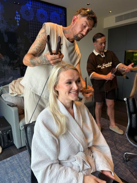Melissa Suffield having her hair styled by two hairdressers.