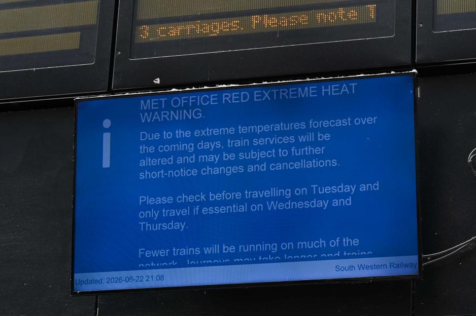 A South Western Railway information screen displaying a Met Office red extreme heat warning, advising passengers of altered services, delays, and cancellations.