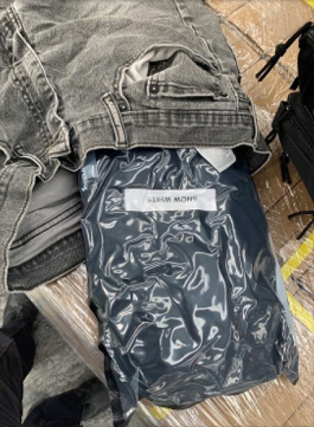 Vacuum-sealed bag labeled "SNOW WHITE" hidden under jeans.