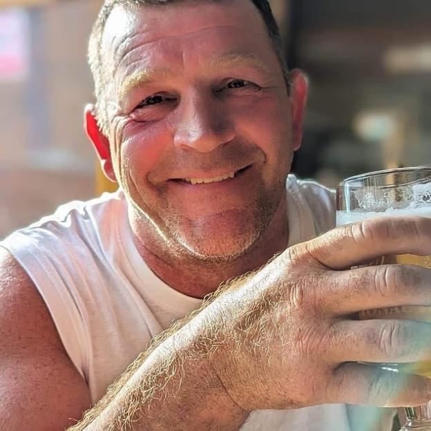 Paul Quinn, accused of rape, smiling and holding a beer.