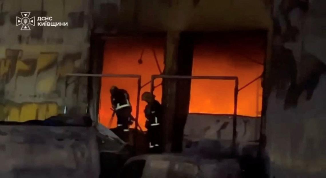 Emergency personnel work at the site of a fire in a warehouse at a location given as Bucha District
