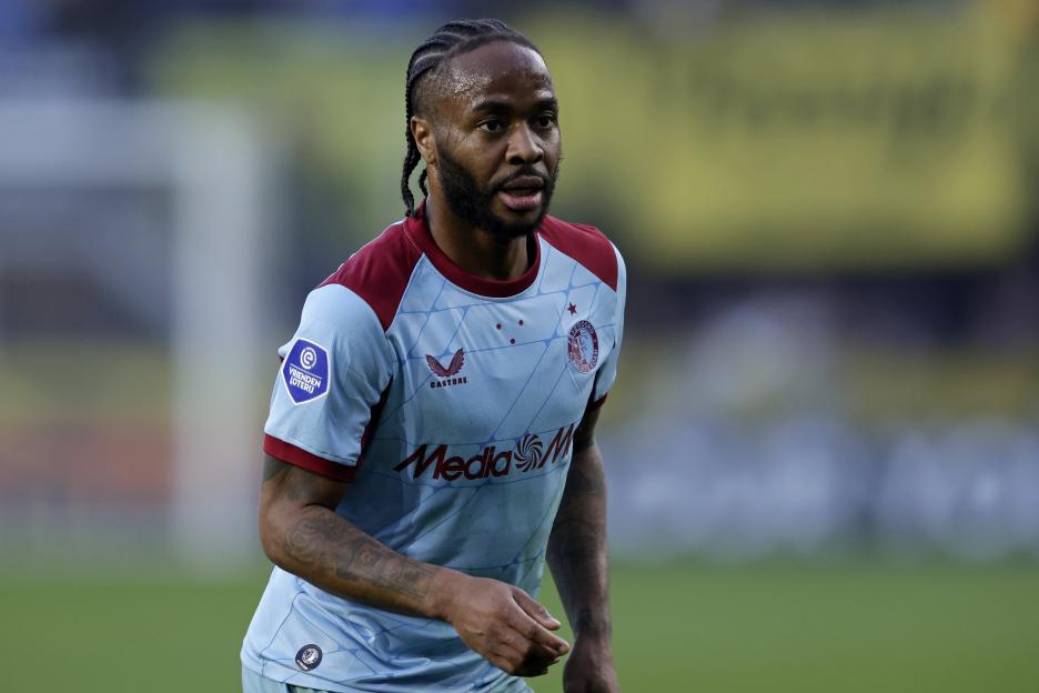 A soccer player in a light blue and maroon jersey looking to the right.