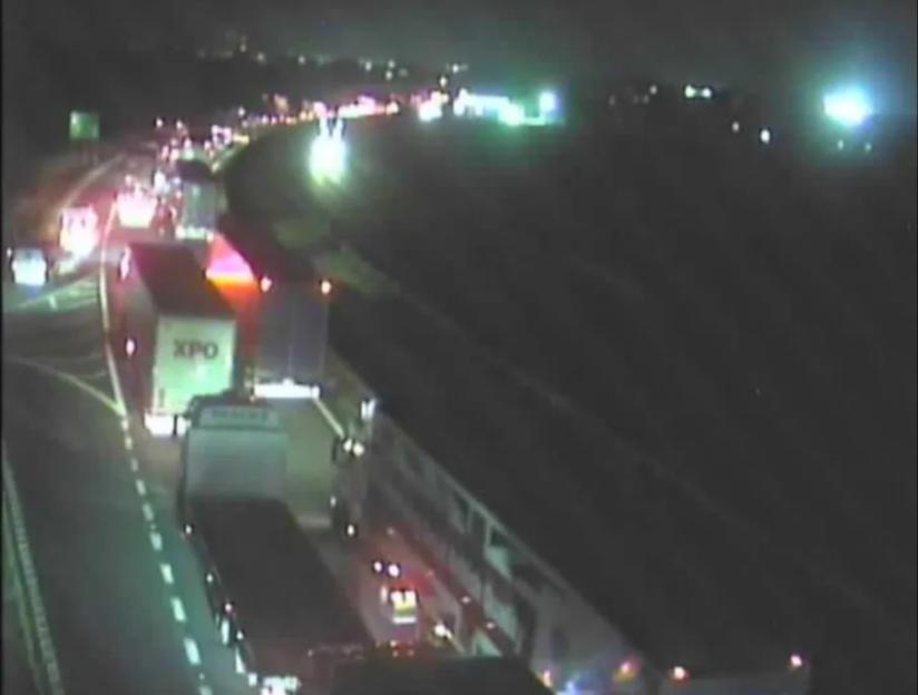 View of a highway at night showcasing several bright car headlights and taillights.