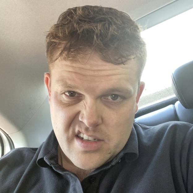 Man with a nose piercing making a disgusted face.