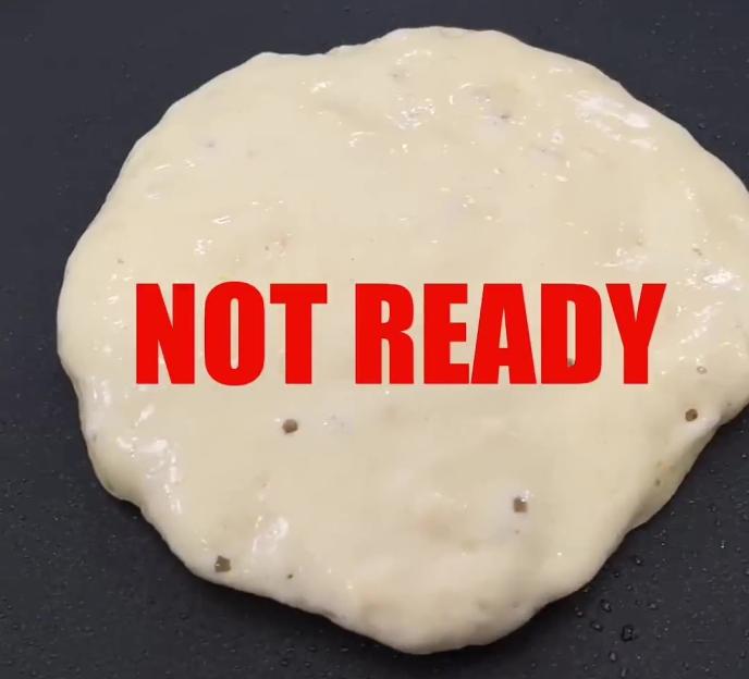 A pancake cooking in a frying pan with the words "NOT READY" overlaid in red.