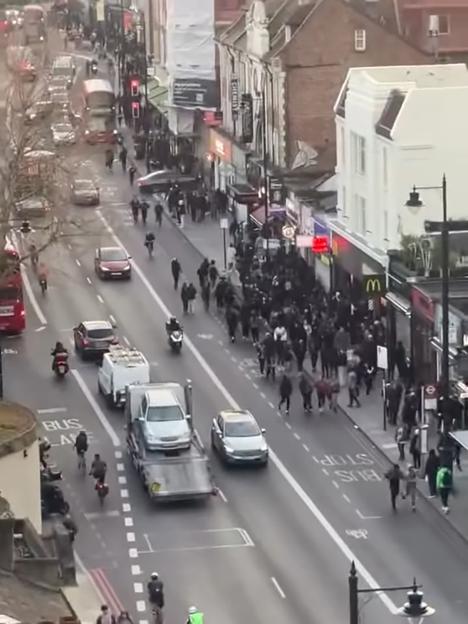 An aerial view of a busy street in Clapham with many pedestrians and vehicles.