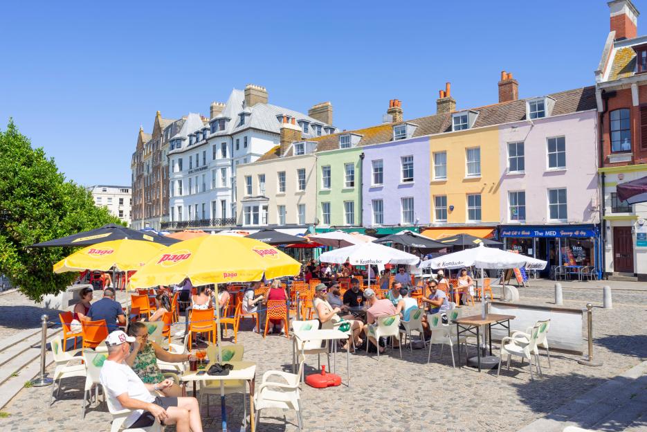 People dine outdoors at cafes and restaurants in Margate Old Town, England.