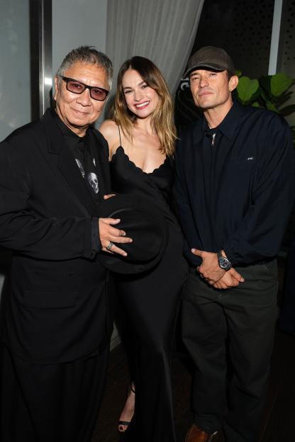 Director Takashi Miike, actor Lily James, and actor Orlando Bloom attend a cocktail party.