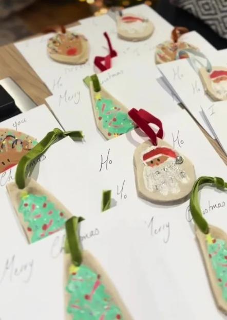 Multiple handmade salt dough ornaments with ribbons, including Santa, reindeer, and Christmas tree designs, on cards.