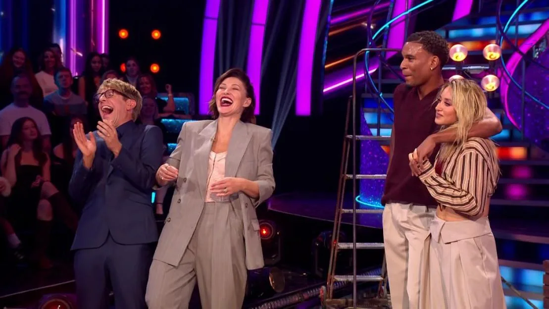 Four contestants on a game show stage laughing.