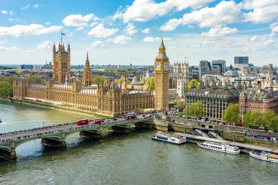 Aerial view of the London cityscape with the Houses of Parliament, Big Ben tower, and the Thames River.