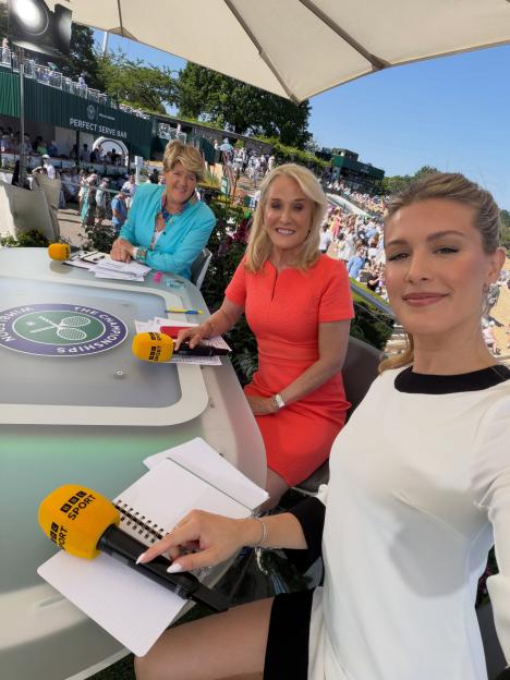 Genie Bouchard and two other women sitting at a table with BBC Sport microphones, with a tennis court in the background.