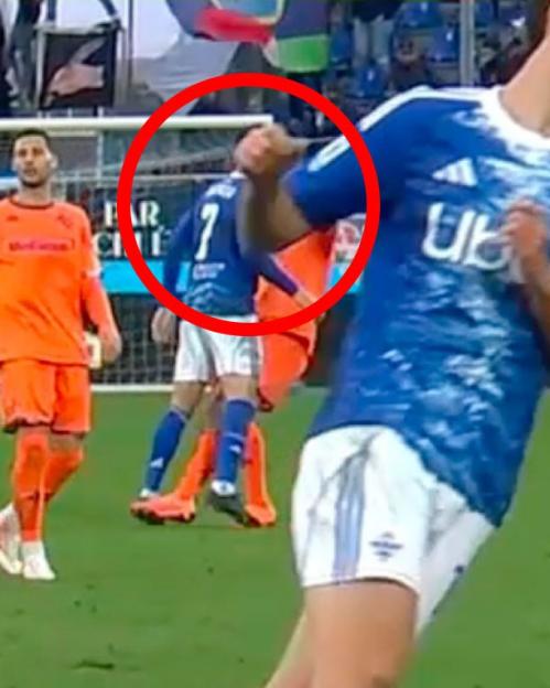 Soccer players on the field with one player's hand making contact with another player's neck.