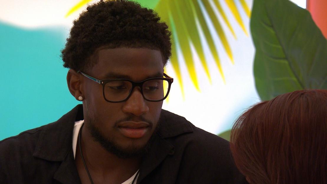 Simba Kudyiwa looking down, talking to someone off-camera.