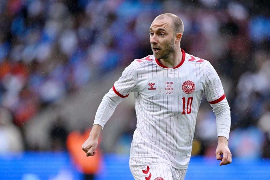 Christian Eriksen in a white and red striped Denmark national football team jersey with the number 10, looking to the right.