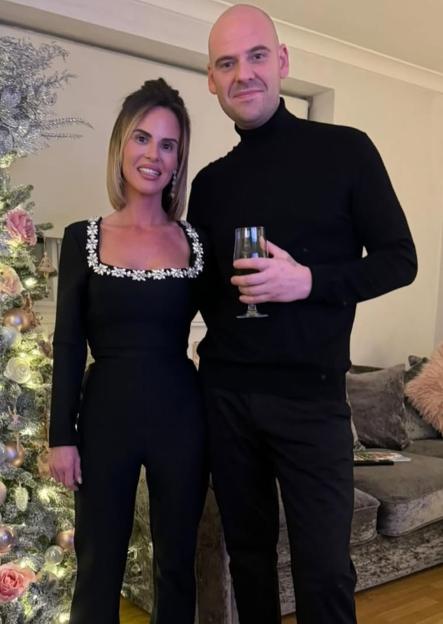 Kaylie Kelliher and Joe Bushnell standing next to a decorated Christmas tree.