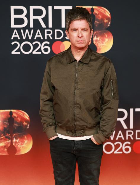 Noel Gallagher poses on a red carpet at the BRIT Awards.