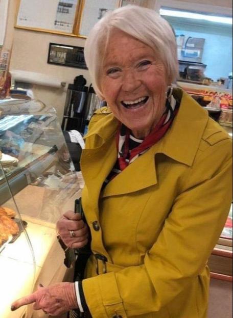 Gloria Stephenson smiling and pointing in a bakery.