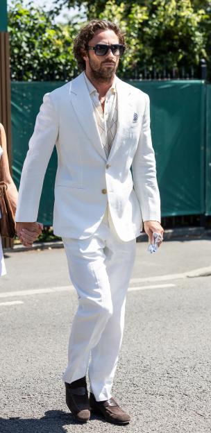 Sam Taylor-Johnson and Aaron Taylor-Johnson hold hands walking outside Wimbledon.