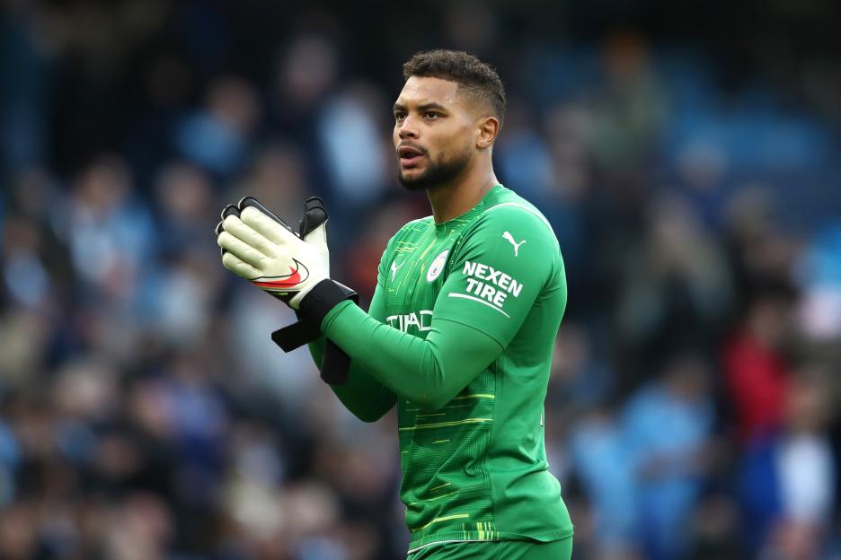 Zack Steffen of Manchester City in a green jersey celebrates after a match.