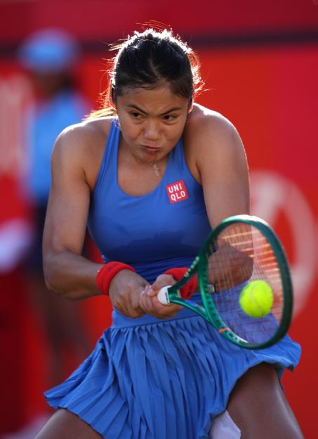 Emma Raducanu hitting a tennis ball with her racket.