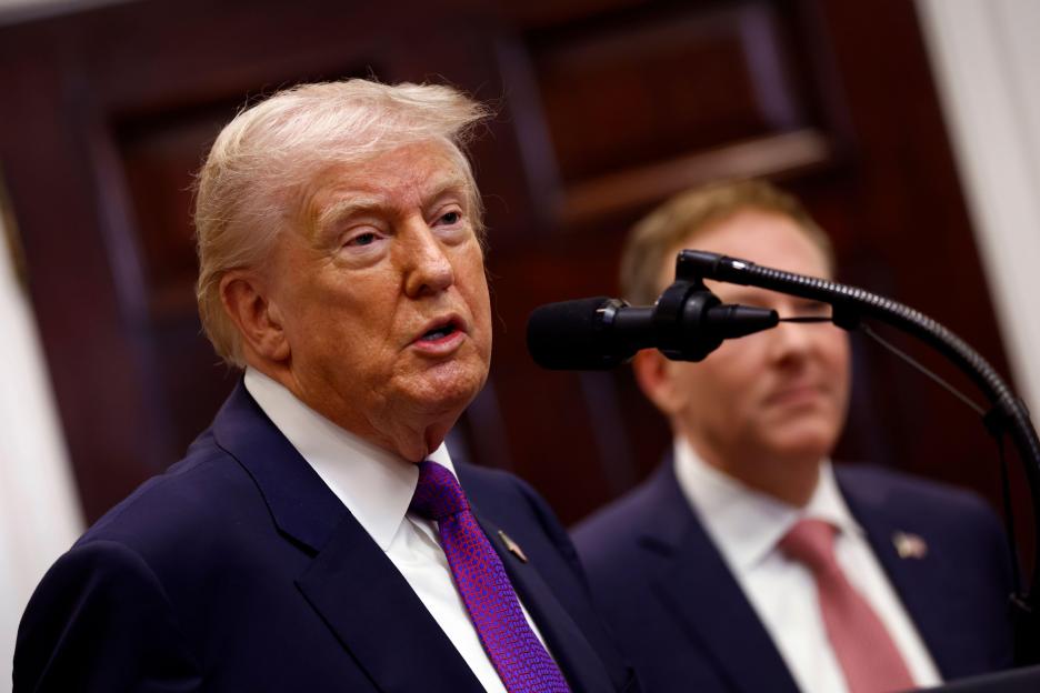 President Donald Trump speaks at a microphone, revoking the EPA's 2009 'endangerment finding,' with EPA Administrator Zeldin behind him.