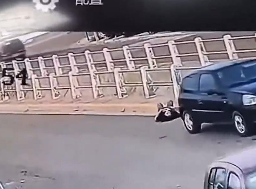 Security footage shows a woman falling to the ground as her car rolls forward and over her chest.
