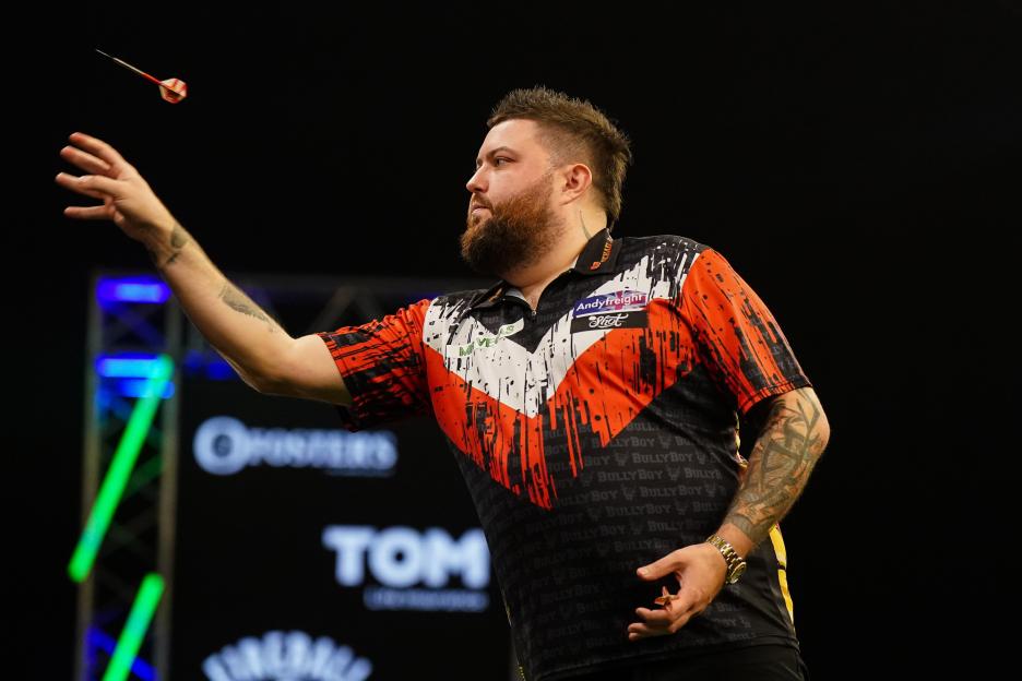 Michael Smith throwing a dart during his match against Nathan Aspinall.