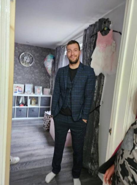 Man in a plaid three-piece suit standing in a room.