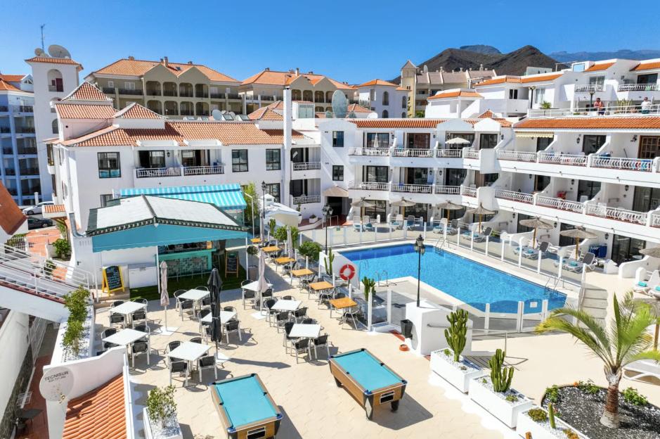 Club Tenerife hotel with a pool and outdoor seating area.