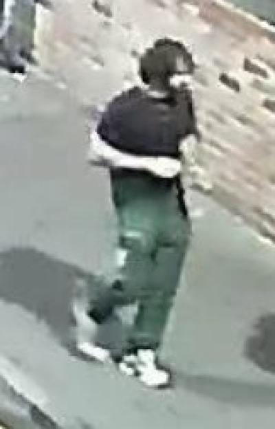 Security camera footage of a person walking, seen from above.