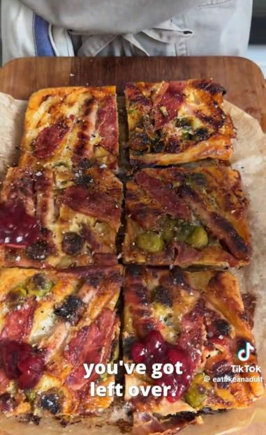 Baked square slices of food with meat, brussels sprouts, and a red sauce.