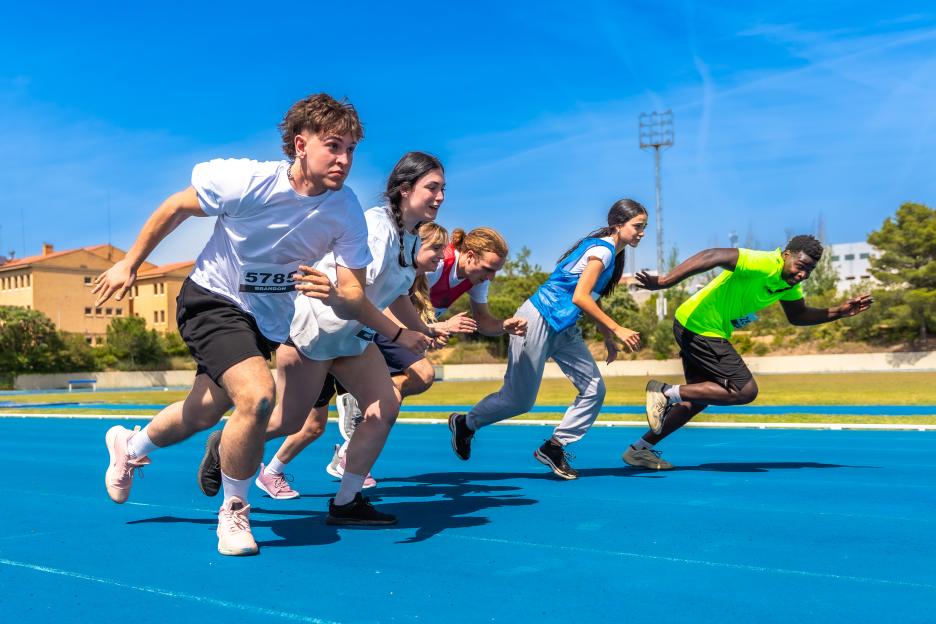 Athletes running on a blue track during a competition.