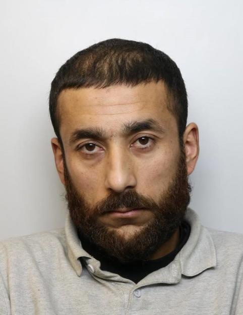 Mugshot of Ahmad Ahmedzai, a man with dark hair and a beard, wearing a light grey polo shirt.