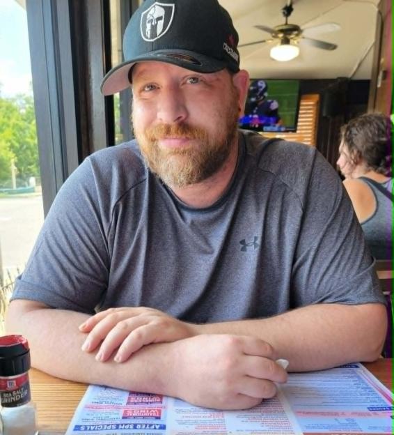 Kris Spencer smiling at a restaurant table.