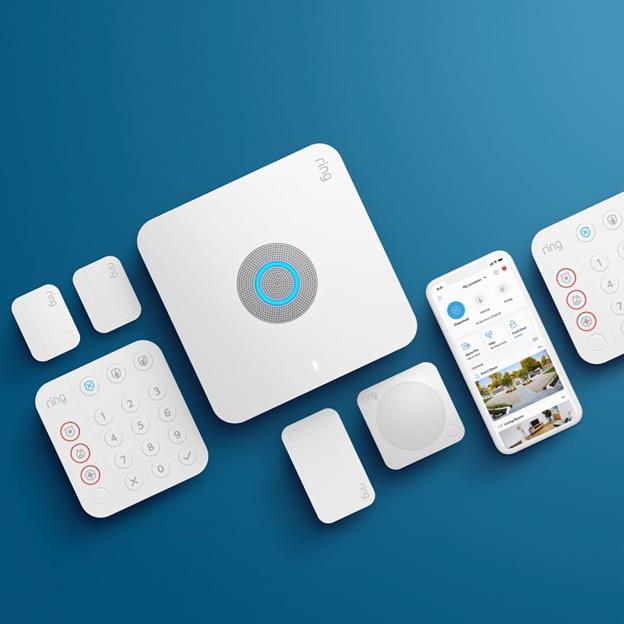 Ring alarm system components, including a base station, keypad, sensors, and a smartphone displaying the Ring app.