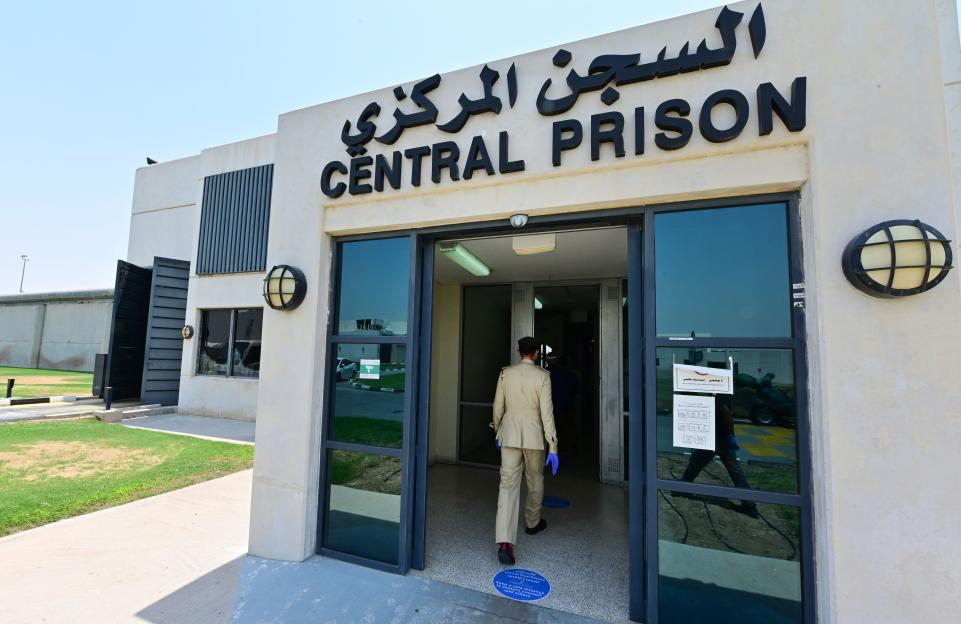 A policeman wearing gloves and a face mask enters Dubai's Al-Awir central prison during the COVID-19 pandemic.