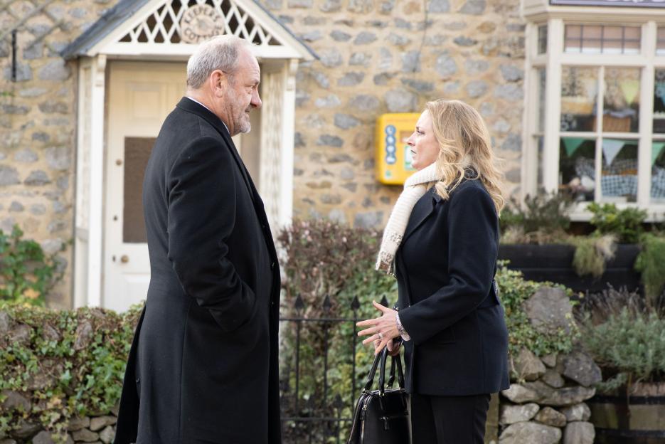 Nicola King and Jimmy King talking outside a stone building.
