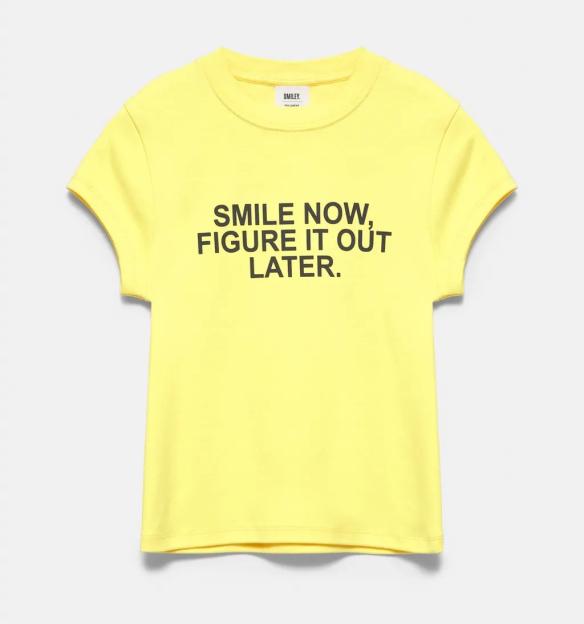 Yellow t-shirt with the text "SMILE NOW, FIGURE IT OUT LATER" in black.