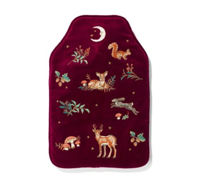 Dark red hot water bottle cover with embroidered woodland animals and plants.